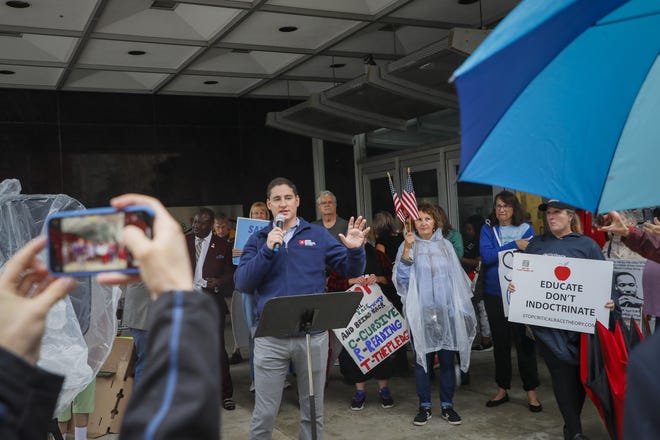 Republican U.S. Senate candidate Josh Mandel, center, speaks to protesters against critical race theory curriculum in Ohio schools on Tuesday, Sept. 21, 2021 outside the State Board of Education in Columbus, Ohio.