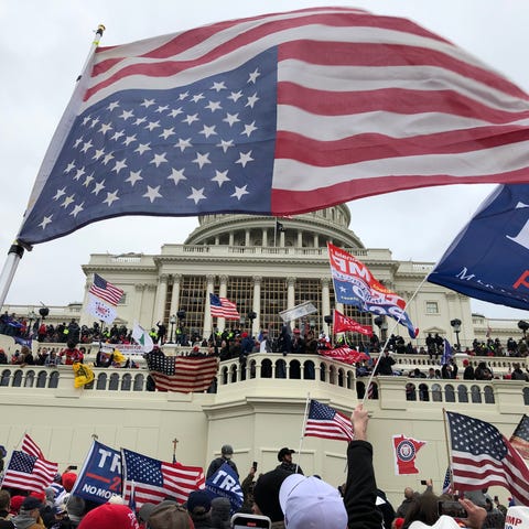 Rioters stand on the West front of the U.S. Capito