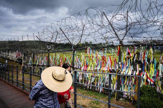Sept. 21, 2021:  Visitors walk past a fence adorned with ribbons with messages written on them, at the Imjingak 'peace park' near the Demilitarized Zone (DMZ) separating North and South Korea, in Paju as South Koreans observe the annual 'Chuseok' thanksgiving holiday which runs from September 20 to 22.