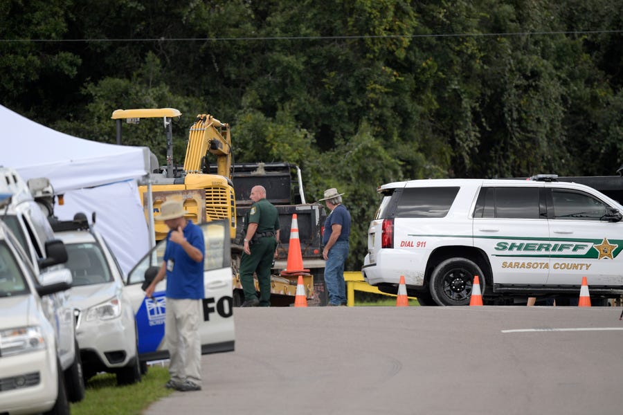 A Sarasota County Sheriff's Office deputy and a Sarasota County worker direct a truck carrying excavating equipment into the Carlton Reserve during a search for Brian Laundrie, Tuesday, Sept. 21, 2021, in Venice, Fla. Laundrie is a person of interest in the disappearance of his girlfriend, Gabrielle "Gabby" Petito.