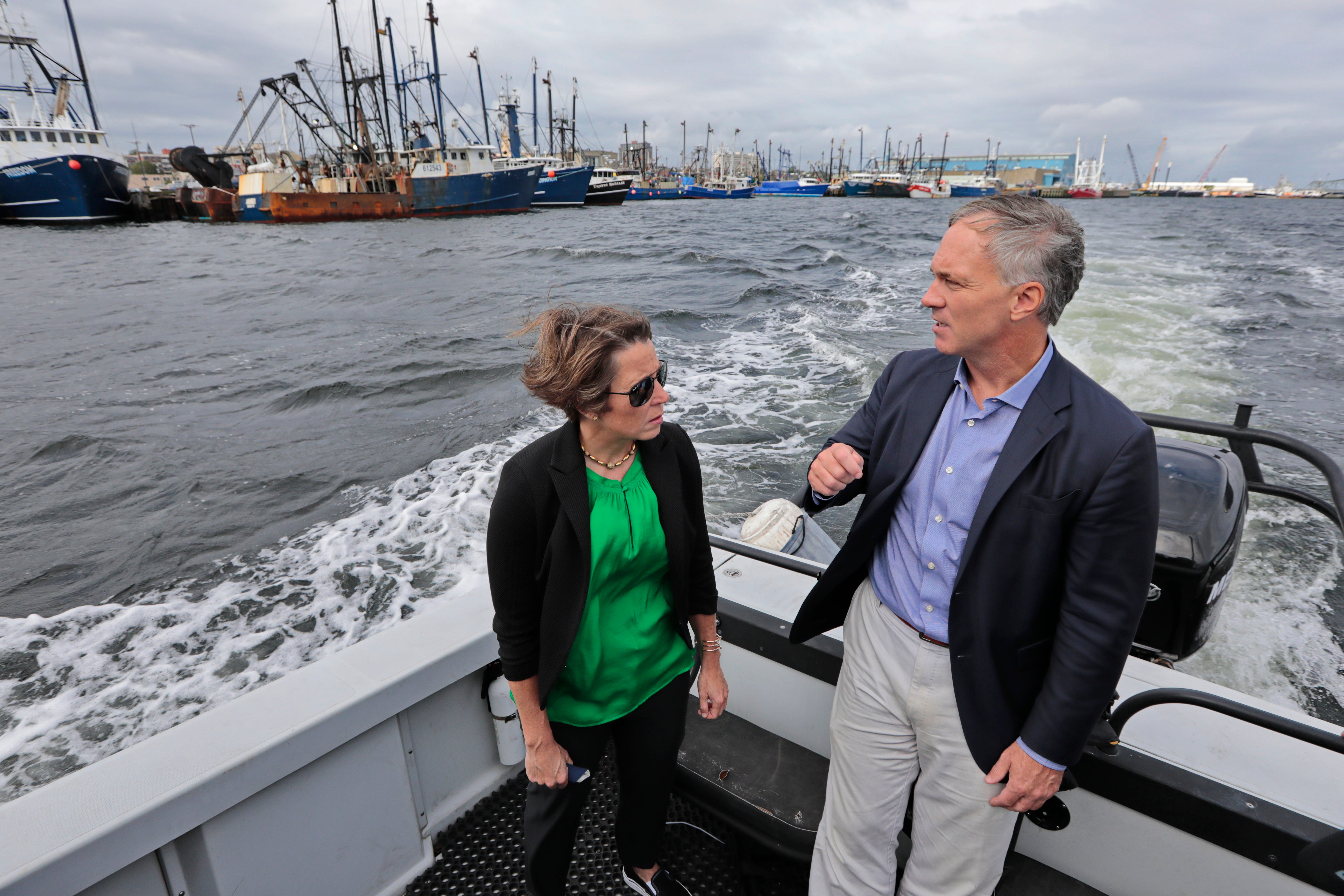 New Bedford Mayor Jon Mitchell speaks with Massachusetts Attorney General Maura Healey during a tour on New Bedford Harbor.