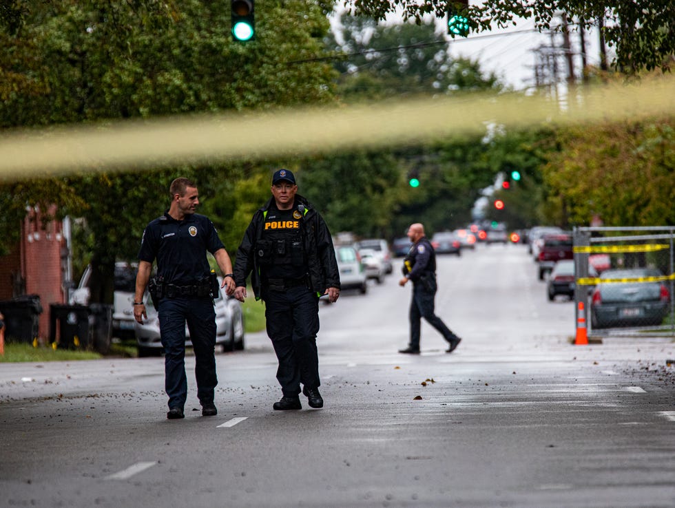 LMPD investigators walk down W. Chestnut street in Louisville's Russell neighborhood after a teenage boy was fatally shot and another wounded in a drive-by shooting at a bus stop. Sept. 22, 2021