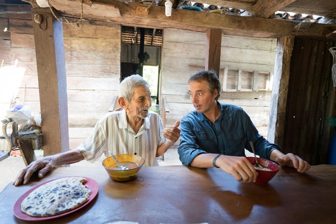 Dan Buettner (right) speaking with a centenarian, a person who has reached the age of 100 years.