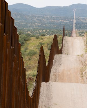 The border fence separating the U.S. and Mexico stretches up and down hillsides and mountains west of Nogales, Ariz.