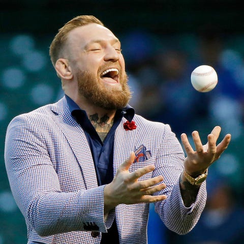 MMA fighter Conor McGregor tosses the ball after t