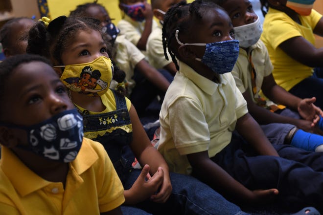 Children sit together during a presentation at the Little Sun People preschool.