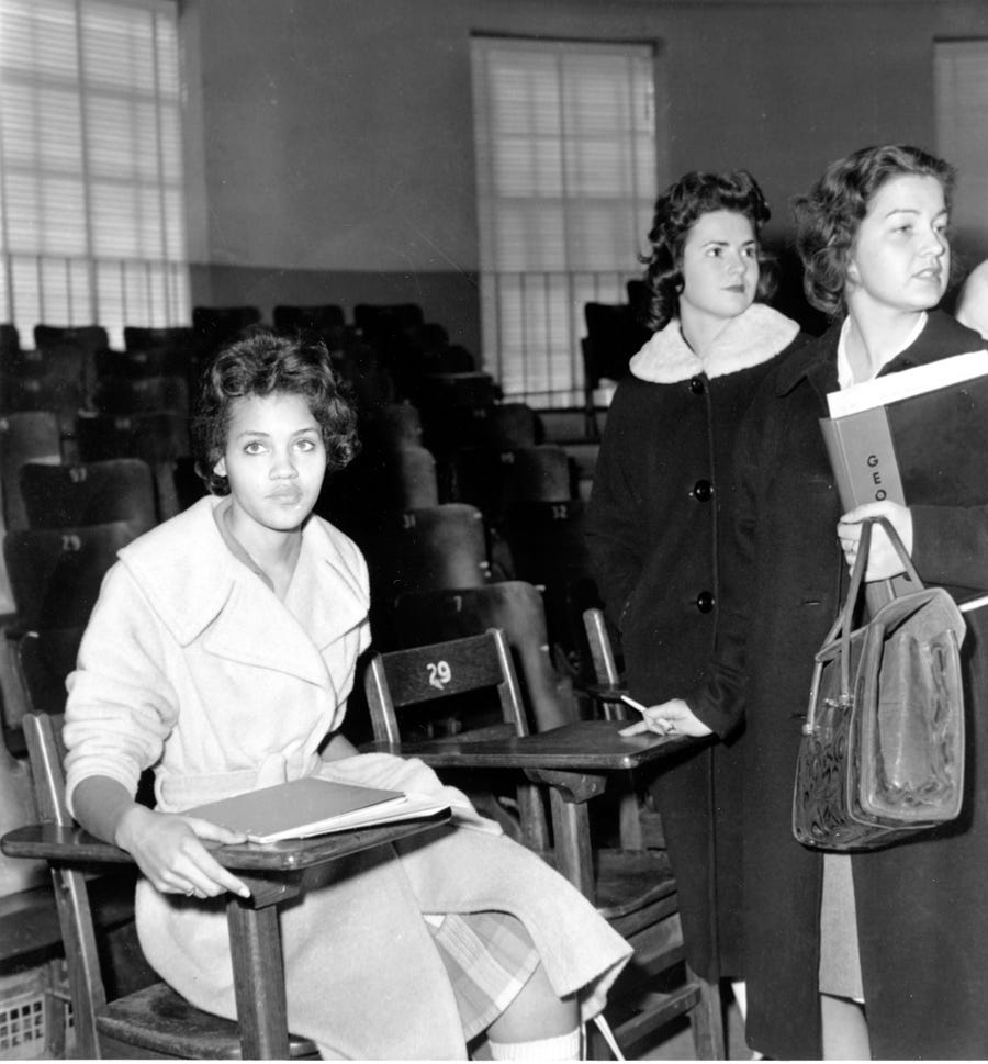 Charlayne Hunter, 18, the first black woman to attend University of Georgia, sits in one of her classes in Athens, Ga., on Jan. 11, 1961. The students at right are unidentified.  Hunter and 19-year-old Hamilton Holmes began classes today under court order. 