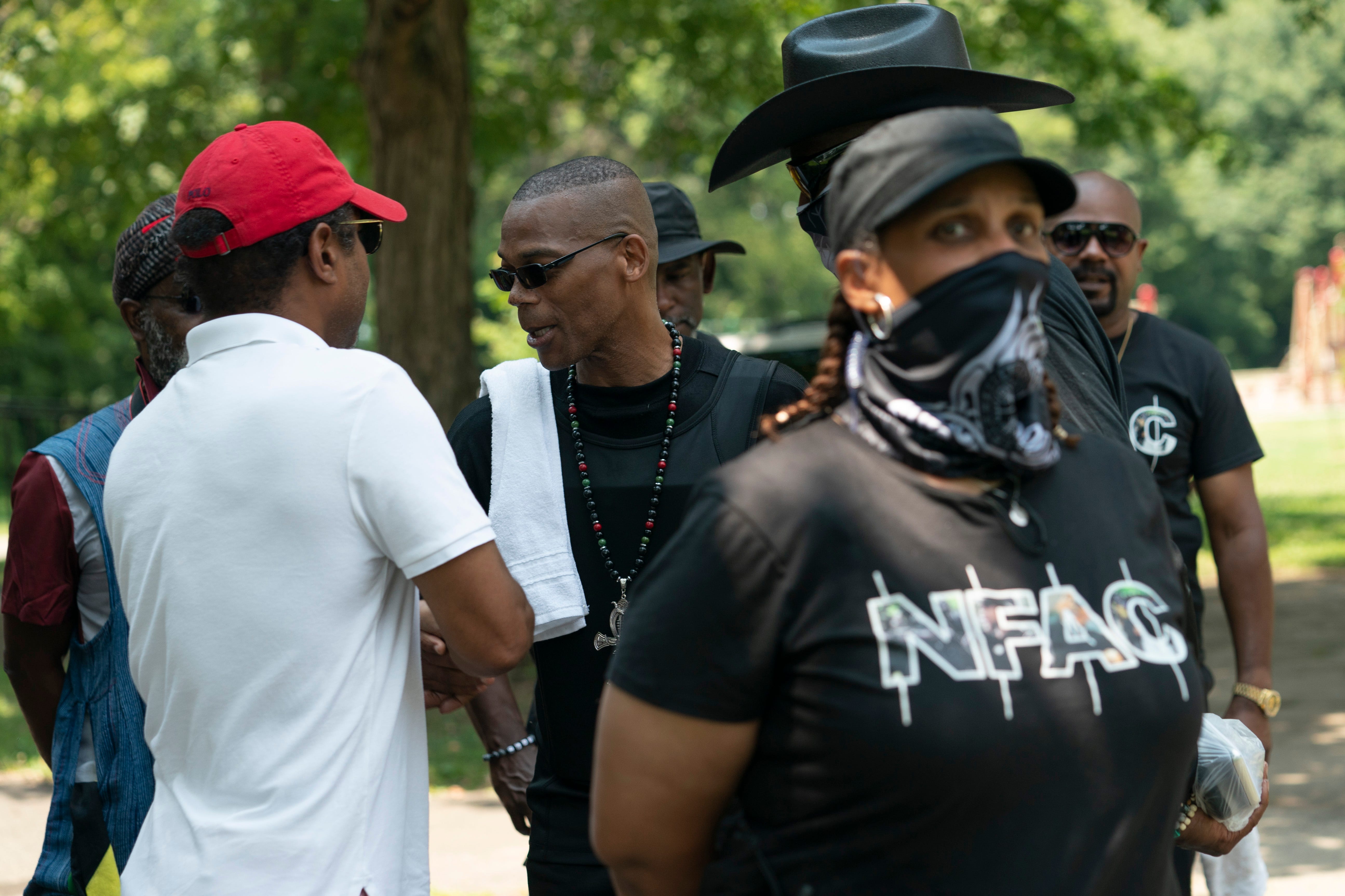 July 24, 2021; Louisville, KY, USA; John Fitzgerald Johnson, known as ÒGrandmaster Jay," greets members and supporters of the Not Fucking Around Coalition (NFAC) as members of his security team stand nearby during the "Feed the People" event at Chickasaw Park, Saturday July 24, 2021 in Louisville, KY.. Mandatory Credit: Jessica Koscielniak-USA TODAY