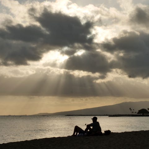People enjoy the sunset on Waikiki Beach in Honolu