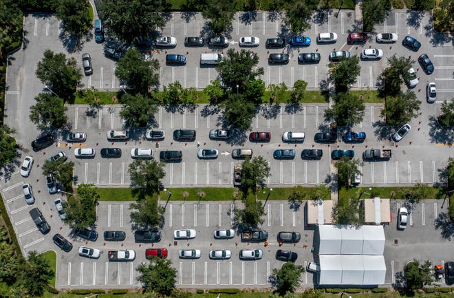 People line up in their cars to get a free COVID-19 test at a site outside the Gardens Branch Library in Palm Beach Gardens.