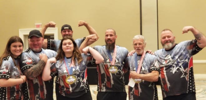 From left, Gracie Westberry, (2 Silver and Bronze), Coach Chuck Westberry (fifth place), Scott Aguglia (fourth), Lily Westberry (2 Gold, 2 Silver, Bronze), Kevin Sams (Gold), Stu Levin (2 Gold) and Marcus Gwin (seventh) celebrate after their performances for Team USA at the IFA World Armwrestling Championships in Orlando on September 20, 2021.