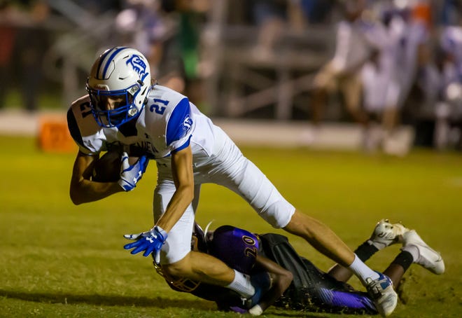 Belleview's Jackson Dennis gains yards Friday against Lake Weir in Candler.