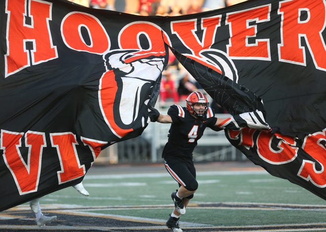 Hoover's Drew Logan bursts through a banner before a Sept. 24, 2021 high school football game against McKinley at Memorial Stadium.