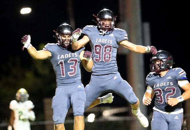 Benedictine's Holden Sapp (13) celebrates with teammates Mac Kromenhoek (98) and Wilkes Albert after scoring a touchdown on an interception in a win over Ware County on Sept. 24.