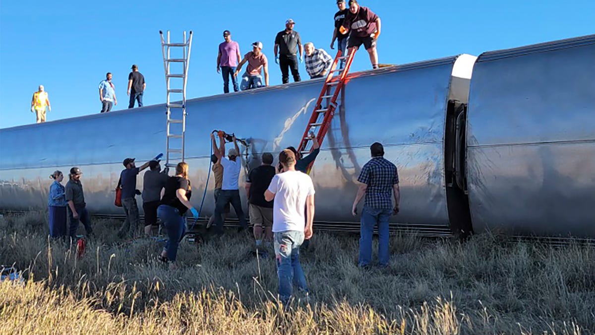In this photo provided by Kimberly Fossen people work at the scene of an Amtrak train derailment on Saturday, Sept. 25, 2021, in north-central Montana. Multiple people were injured when the train that runs between Seattle and Chicago derailed Saturday, the train agency said. (Kimberly Fossen via AP) ORG XMIT: LA602