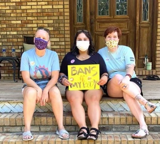 Alison Smith, Carollyn Taylor and Heather Brescher pose with a sign reading "Bans off my body." The women have helped organize a march in support of reproductive rights in Fort Walton Beach on Saturday.
