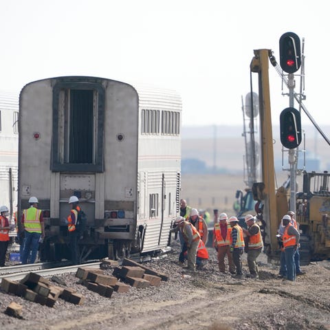 Workers examine a train car, Monday, Sept. 27, 202