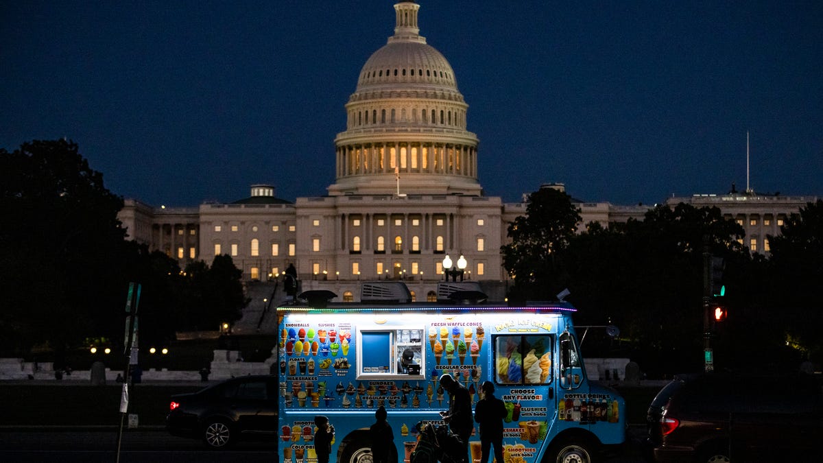 A family buys ice cream at a food truck on the National Mall with the U.S. Capitol building in the distance on September 26, 2021 in Washington, DC. Congress is heading into the week with the deadline for debt ceiling negotiations approaching and as President Joe Biden said on Friday that the infrastructure bill remains at a stalemate.