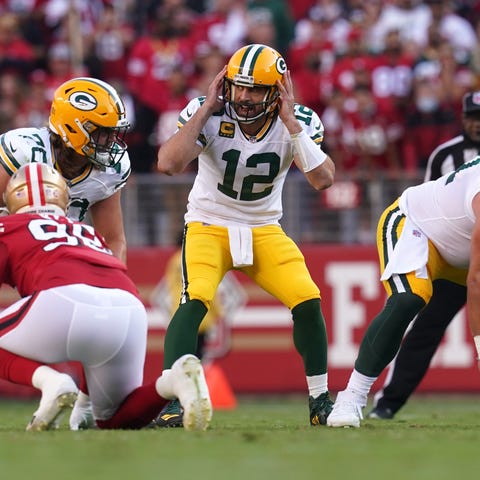 Packers quarterback Aaron Rodgers (12) directs the