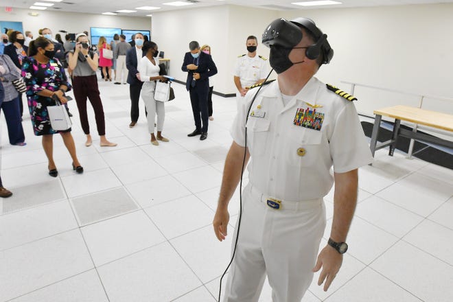 Navy Cap. Matthew Pottenburgh tries on a virtual reality headset to experience a three-dimensional simulation of the Navy's Poseidon P-8 aircraft at a new Boeing training development center not far from Naval Air Station Jacksonville. The center is designed to be a virtual maintenance training center for aircraft crews.