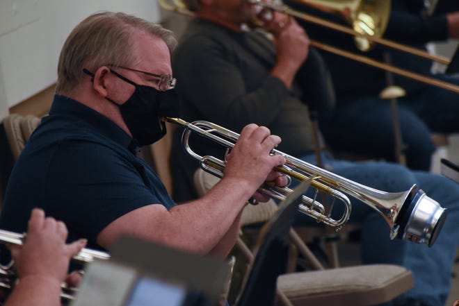 FILE — Bremerton WestSound Symphony member Chuck Greene dons a mask with a hole for his mouthpiece during rehearsal. The symphony was one of four Bremerton-based nonprofits to receive an anonymous $250,000 donation from a Bremerton resident.