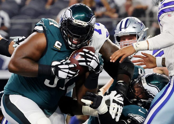 Philadelphia Eagles defensive tackle Fletcher Cox recovers a fumble by Dallas Cowboys quarterback Dak Prescott for a touchdown during the first quarter at AT&T Stadium.