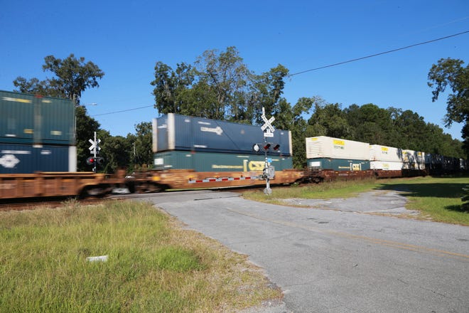 A train passes over Priscilla D Thomas Way blocking all access to the neighborhood as it makes its way through. At times the train will stop blocking the entrance to the neighborhood for long periods of time.