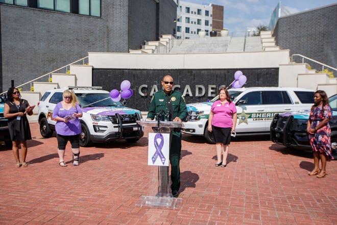 Leon County Sheriff Walt McNeil, center, reads staggering statistics of domestic violence that occurs in Leon County during a press conference where local law enforcement offices unveiled vehicles featuring their "End the Silence on Domestic Violence" campaign Wednesday, Sept. 29, 2021.