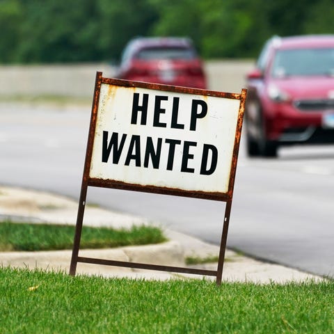 A help-wanted sign is displayed at a gas station i