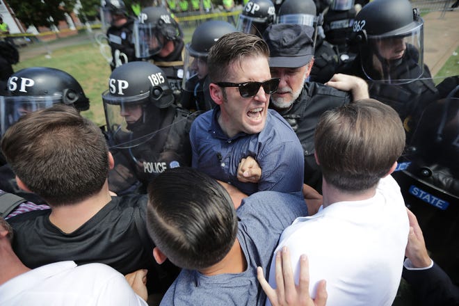 White nationalist Richard Spencer (center) and his supporters clash with Virginia State Police in Emancipation Park after the "Unite the Right" rally was declared an unlawful gathering Aug. 12, 2017 in Charlottesville, Virginia. Hundreds of white nationalists, neo-Nazis and members of the "alt-right" clashed with anti-fascist protesters and police as they attempted to hold a rally in Emancipation Park, where a statue of Confederate General Robert E. Lee was slated to be removed.
