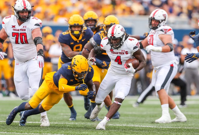 Texas Tech running back SaRodorick Thompson (4) dashes through a hole during the Red Raiders' 23-20 victory last year at West Virginia. The Red Raiders host the Mountaineers at 2 p.m. Saturday at Jones AT&T Stadium.