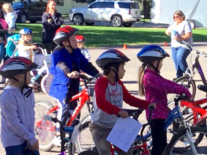 Children listen to bike safety instruction during the Ridin’ with the Son in 2021 bike safety rodeo event.