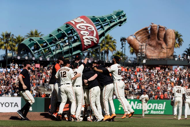 The San Francisco Giants celebrate after defeating the San Diego Padres in a baseball game in San Francisco, Sunday, Oct. 3, 2021. (AP Photo/John Hefti)