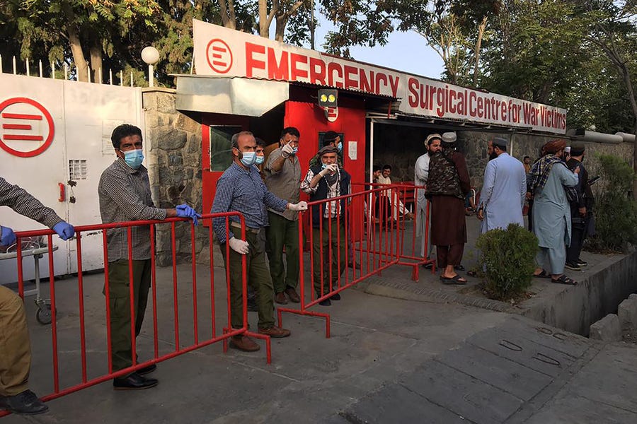 Afghan medical staff members stand at the entrance of a hospital as they wait to receive the victims of an explosion in Kabul on Oct. 3, 2021.