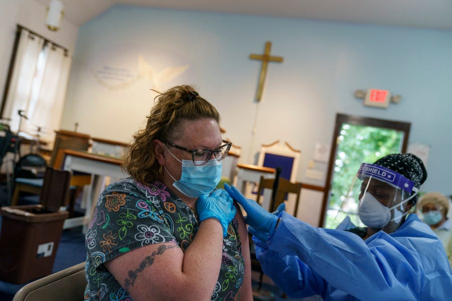 Amanda Gomes, left, receives her COVID-19 vaccine from family nurse practitioner Temperance Taylor during a clinic set up in Bethel AME Church Friday, Sept. 24, 2021, in Providence, R.I.