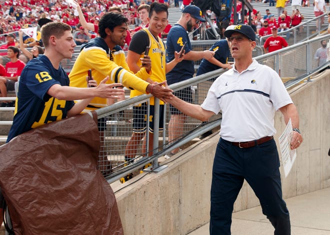 Michigan head coach Jim Harbaugh greets fans prior to the Wolverines' game against the Wisconsin Badgers.