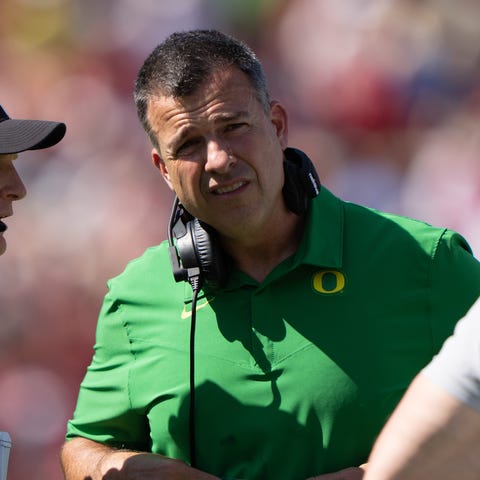 Oregon head coach Mario Cristobal speaks with a re