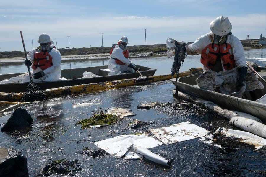 Cleanup contractors deploy skimmers and floating barriers known as booms to try to stop further oil crude incursion into the Wetlands Talbert Marsh in Huntington Beach, Calif., on Oct. 3. One of the largest oil spills in recent Southern California history fouled popular beaches and killed wildlife while crews scrambled to contain the crude.