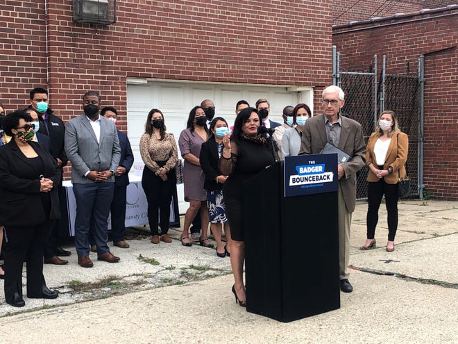 Jessica Cavazos, President and CEO of the Latino Chamber of Commerce, speaks at a news conference Tuesday, Oct. 5 at the Dominican Center in Milwaukee. Gov. Tony Evers, left, announced that $75 million in federal coronavirus aid will go toward two grant programs aiming to help small businesses that have been disproportionately affected by the pandemic.