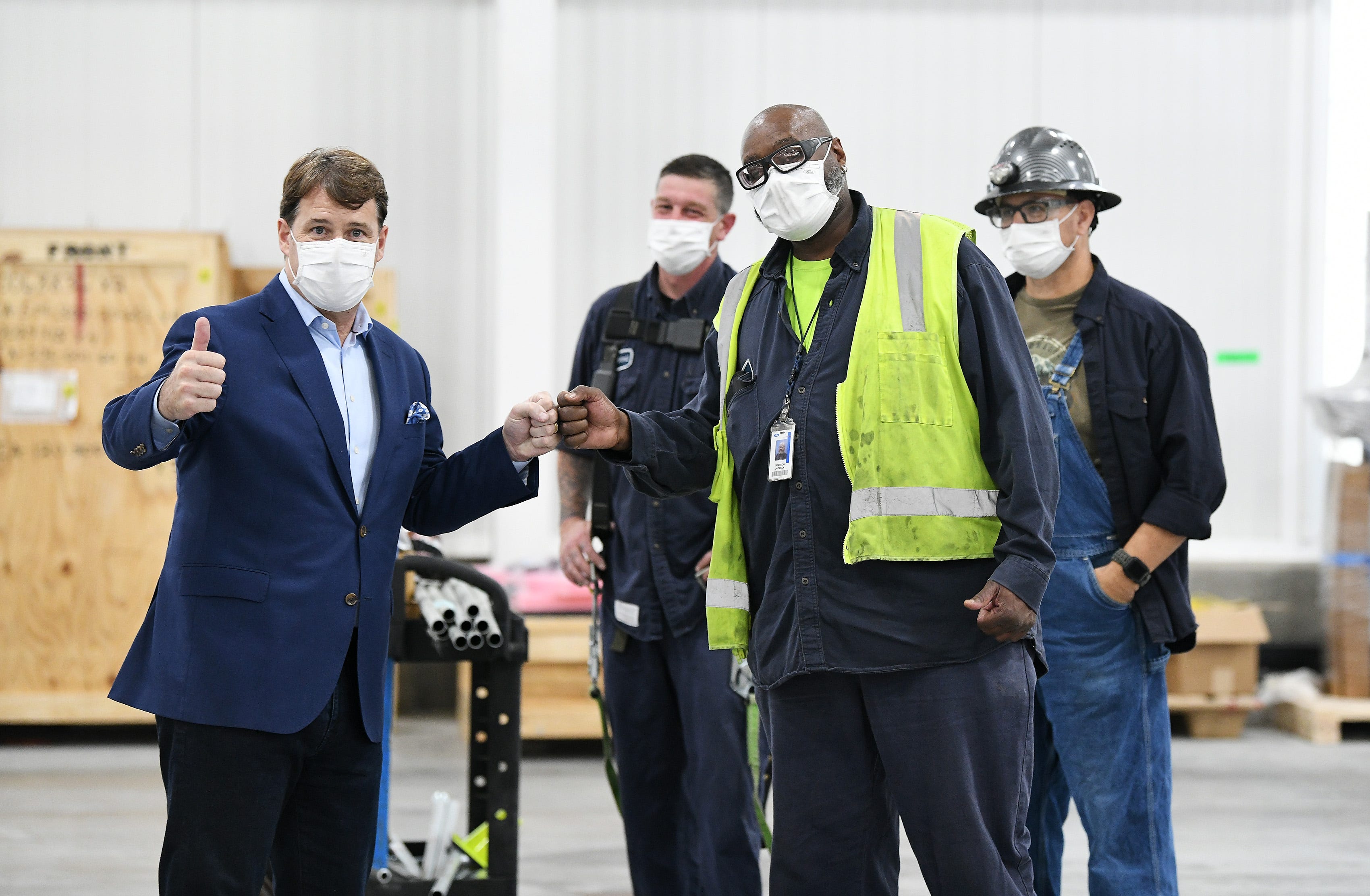 Ford CEO Jim Farley, left, speaks to electricians Kevin Johnson, Grady Jackson and Dan Bandlow at the Rouge Electric Vehicle Center in Dearborn on Oct. 5, 2021.