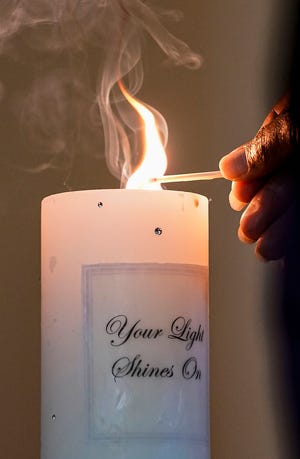 A candle is lit during the Domestic Violence Network annual memorial ceremony honoring the lives of those lost to domestic violence Tuesday, Oct. 5, 2021, at Meridian Street United Methodist Church, Indianapolis. Each attendee lit a candle for the names of those lost to domestic violence. 