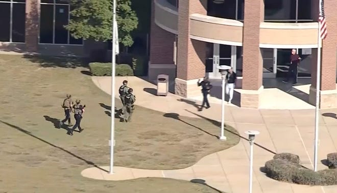 Law enforcement officers arrive at Timberview High School early Wednesday in Arlington, Texas. Authorities say a student opened fire inside the Dallas-area high school during a fight.