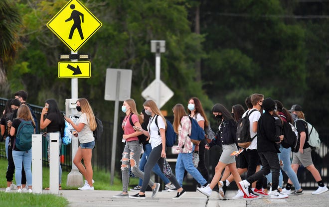 Sarasota High School students cross School Ave. as the first bell rings Monday morning, Aug. 31, 2020 on the first day of school in Sarasota County.