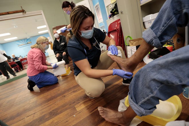 UMass Dartmouth nursing student Skyla Bernardo cleans the feet of Kimyata Richardson during the weekly Mercy Meals podiatry clinic for the homeless at its facility on Purchase Street in New Bedford.