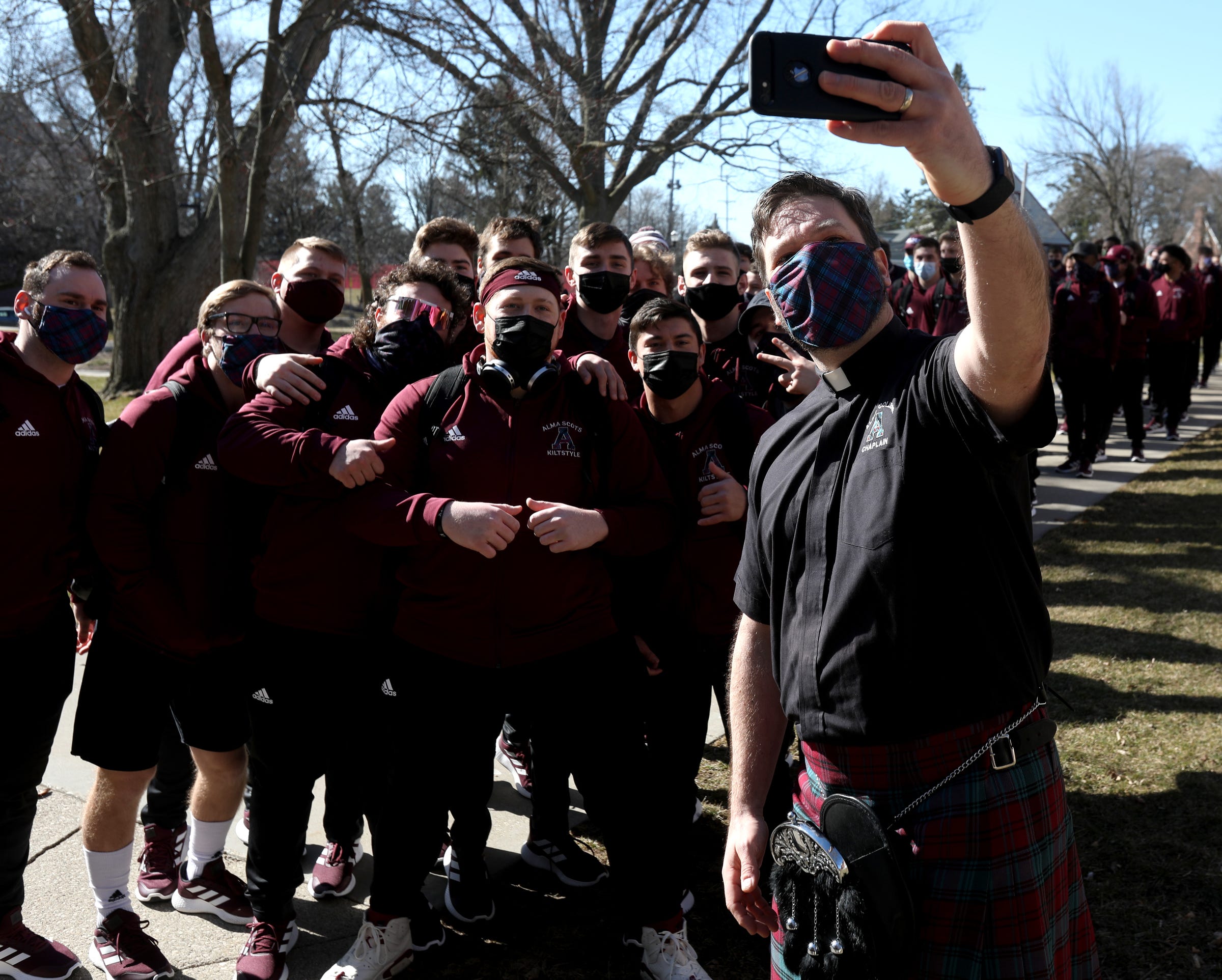 Andrew Pommerville, the Alma College chaplain wanted a selfie with some members of the Alma football team before they marched off in line following bagpipes to the football field for their game against Adrian College in Alma, Michigan on Saturday, March 20, 2021.
