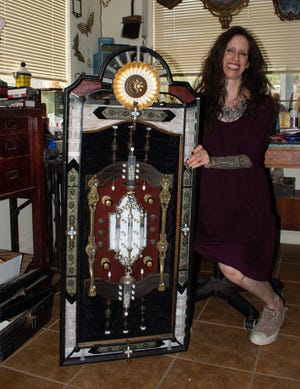 Artist Wendy Gadzuk poses with an assemblage piece she made using medical waste Oct. 6 in her Morongo Valley studio.