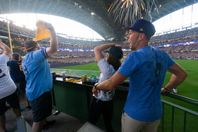 Fans celebrate after Milwaukee Brewers first baseman Rowdy Tellez (11) hits a two-run homer during the seventh inning of their National League Division Series game against the Atlanta Braves at American Family Field in Milwaukee, Wis.