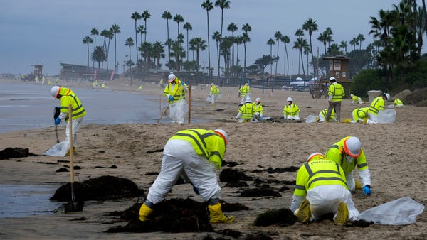 Workers in protective suits clean the contaminated