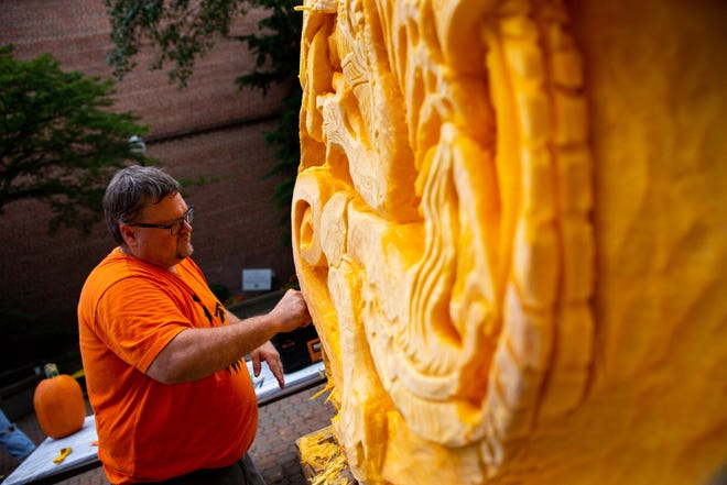 Greg Butauski, a certified master carver, works on a carving of a Xenomorph from the Alien movies during Fall Fest in October 2021 in downtown Holland.