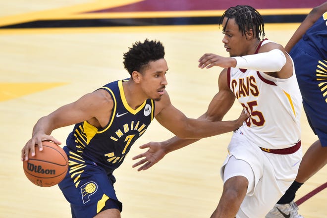 Oct 8, 2021; Cleveland, Ohio, USA; Indiana Pacers guard Malcolm Brogdon (7) drives against Cleveland Cavaliers forward Isaac Okoro (35) in the second quarter at Rocket Mortgage FieldHouse. Mandatory Credit: David Richard-USA TODAY Sports